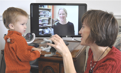 a telehealth session, the child and mom communicating with a health professional with their TV